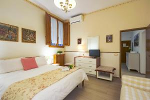 a bedroom with a bed and a desk and a television at The Heart of Florence in Florence