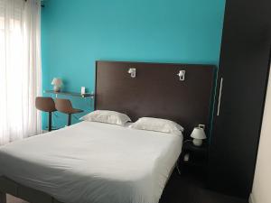 1 dormitorio con 1 cama blanca de fondo azul en La Pergola d'Arcachon, en Arcachon