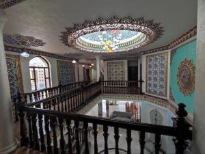 een trap in een gebouw met een kroonluchter bij Ayvan Plaza hotel in Bukhara