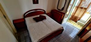 un piccolo letto rosso in una stanza con finestra di La Stanza di Nunziatina a Ischia
