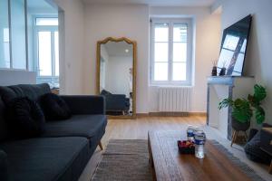 uma sala de estar com um sofá e um espelho em Le Voltaire • Proche Gare • Moderne em Châteauroux