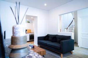 sala de estar con sofá azul y mesa en Le Voltaire • Proche Gare • Moderne en Châteauroux