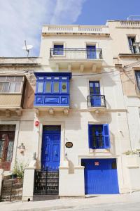 un edificio blanco con puertas y ventanas azules en Di Valentina Boutique Living en Sliema