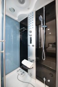 a shower with a glass door in a bathroom at Omeo Suites in Alhambra