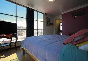 a bedroom with a large bed and a large window at The Rooftop Bolivia in La Paz