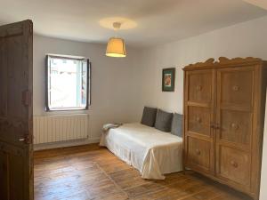 ein Schlafzimmer mit einem Bett, einer Kommode und einem Fenster in der Unterkunft La Toscana en Lozoya in Alameda del Valle