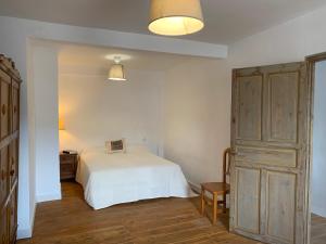 sypialnia z białym łóżkiem i drewnianą podłogą w obiekcie La Toscana en Lozoya w mieście Alameda del Valle