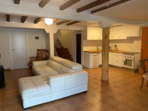 a living room with a white couch and a kitchen at La Toscana en Lozoya in Alameda del Valle