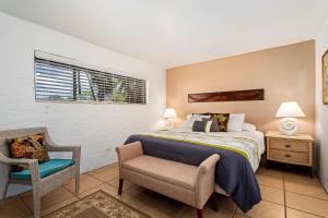 a bedroom with a bed and a chair and a window at Casa De Emdeko 230 in Kailua-Kona +32 photos