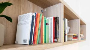 a row of books sitting on a book shelf at Casa vacanze Il Cammino Assisi in Assisi
