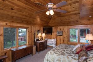 Un dormitorio con una cama y un ventilador de techo. en Whiskey River Cottages formerly Seaway Slips, en Clayton