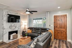 a living room with a leather couch and a fireplace at Captivating 3 Bedroom Home W Hot Tub in Citrus Heights
