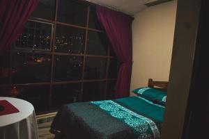 Schlafzimmer mit einem Bett und einem Fenster mit Aussicht in der Unterkunft Santa Pacha in Sucre