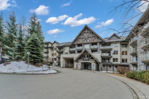a large apartment building with a driveway at Best ski in ski out condo #3 in Aspens in Whistler