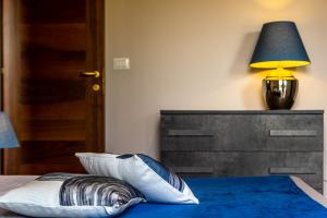 a bedroom with a bed with a lamp and pillows at Villetta Desiderio Apartment in Giardini Naxos