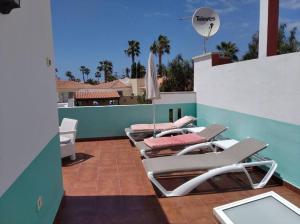 a row of chaise lounge chairs on a roof at Maison en duplex & rooftop in Callao Salvaje