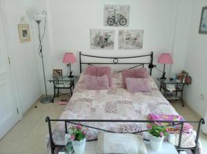 a bedroom with a bed with pink pillows and two tables at Maison en duplex & rooftop in Callao Salvaje +11 photos