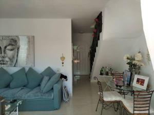 a living room with a blue couch and a table at Maison en duplex & rooftop in Callao Salvaje