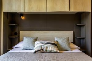 a bedroom with a large bed with a wooden headboard at Villetta Desiderio Apartment in Giardini Naxos +18 photos