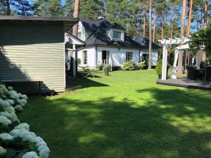 a backyard with a house and a yard with green grass at Villa Muusa in Tallinn