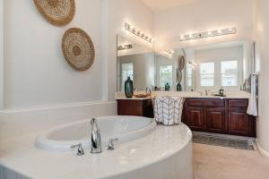 a large bathroom with a tub and a large mirror at Elegant Mediterranean Hotel Style Home W Hot Tub in Sacramento
