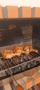 dos piezas de comida cocinando en una parrilla en Donna Nega Alojamento Local, en Caminha