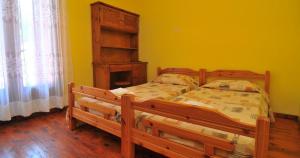 ein Schlafzimmer mit einem Holzbett und einer gelben Wand in der Unterkunft Pansion panorama family apartment in Skala Marion