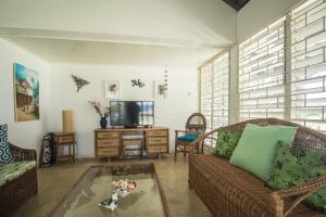 a living room with a couch and a tv at Island Breeze Beach Villa in Carey Park