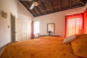 Island Breeze Beach Villa في Carey Park: غرفة نوم بسرير كبير مع بطانية برتقالية