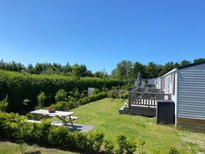 een tuin met een picknicktafel en een bank bij Chalet Relax in Oostkapelle