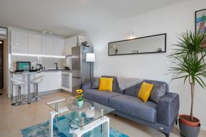 a living room with a blue couch and a kitchen at Blue Horizon in Dubrovnik