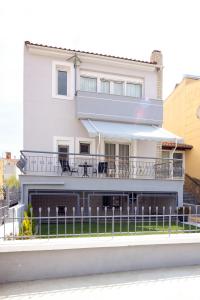 a white house with a fence in front of it at Villa Bolero in Iraklitsa