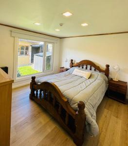 a large bed in a bedroom with a large window at Gi´s House 4Pax in Ushuaia