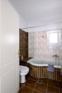 a bathroom with a tub and a toilet and a sink at Villa Bolero in Iraklitsa