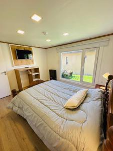 1 dormitorio con 1 cama grande y ventana grande en Gi´s House 4Pax en Ushuaia