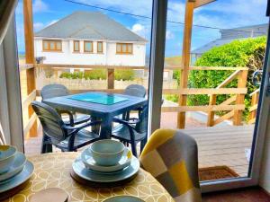 a patio with a table and chairs on a deck at Trevone Bay Seaside Home For 4 - Close To Beach and Padstow in Padstow