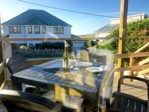 a table with a bottle of wine on a deck at Trevone Bay Seaside Home For 4 - Close To Beach and Padstow in Padstow