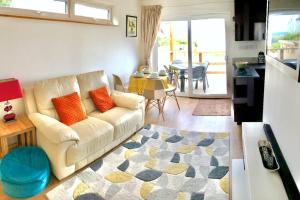 a living room with a white couch and a table at Trevone Bay Seaside Home For 4 - Close To Beach and Padstow in Padstow