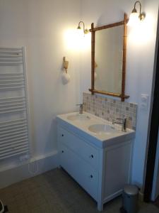 a bathroom with a sink and a mirror at L'ancien prieuré in Lorrez-le-Bocage