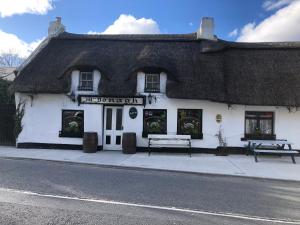 a thatched building with a bench in front of it at Self catering Oranmore in Oranmore