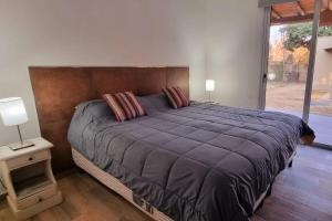 ein Schlafzimmer mit einem großen Bett und einem großen Fenster in der Unterkunft OM. Casas de descanso in Ciudad Lujan de Cuyo