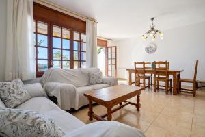 ein Wohnzimmer mit einem Sofa und einem Tisch in der Unterkunft Hauzify I Casa Mirador in L'Ametlla de Mar