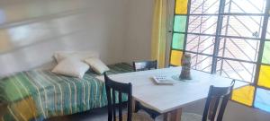ein Zimmer mit einem Tisch und einem Bett und einem Fenster in der Unterkunft San Andrés in Salta + 12 Fotos