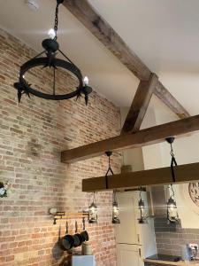 a chandelier in a kitchen with a brick wall at Lynford Holiday Cottages nestled in the heart of Thetford Forest in Mundford