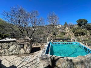 a large swimming pool in a stone building with at Casa Fidelina II Miraflores de la Sierra in Miraflores de la Sierra
