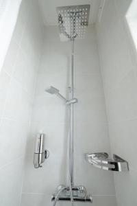 a shower in a bathroom with white tiles at Di Valentina Boutique Living in Sliema