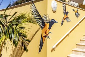 a painting of birds on the side of a building at Bayside Boutique Hotel - Blue Bay Golf & Beach Resort in Willemstad