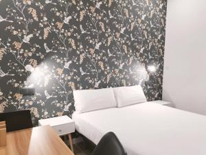 1 dormitorio con cama y papel pintado en blanco y negro en Apartamentos Margarita by gaiarooms, en Salamanca
