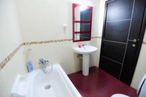 a bathroom with a tub and a sink and a toilet at Seaside Xlendi apartment in Xlendi