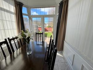 a dining room table with a vase of flowers on it at Cosy Family Get-Away 4 Bedrooms 7 Beds 2 Bathrooms in Blackpool